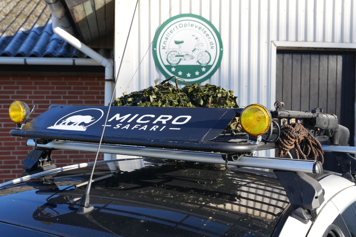 Microsafari-skilt og gule lygter på bilens tag